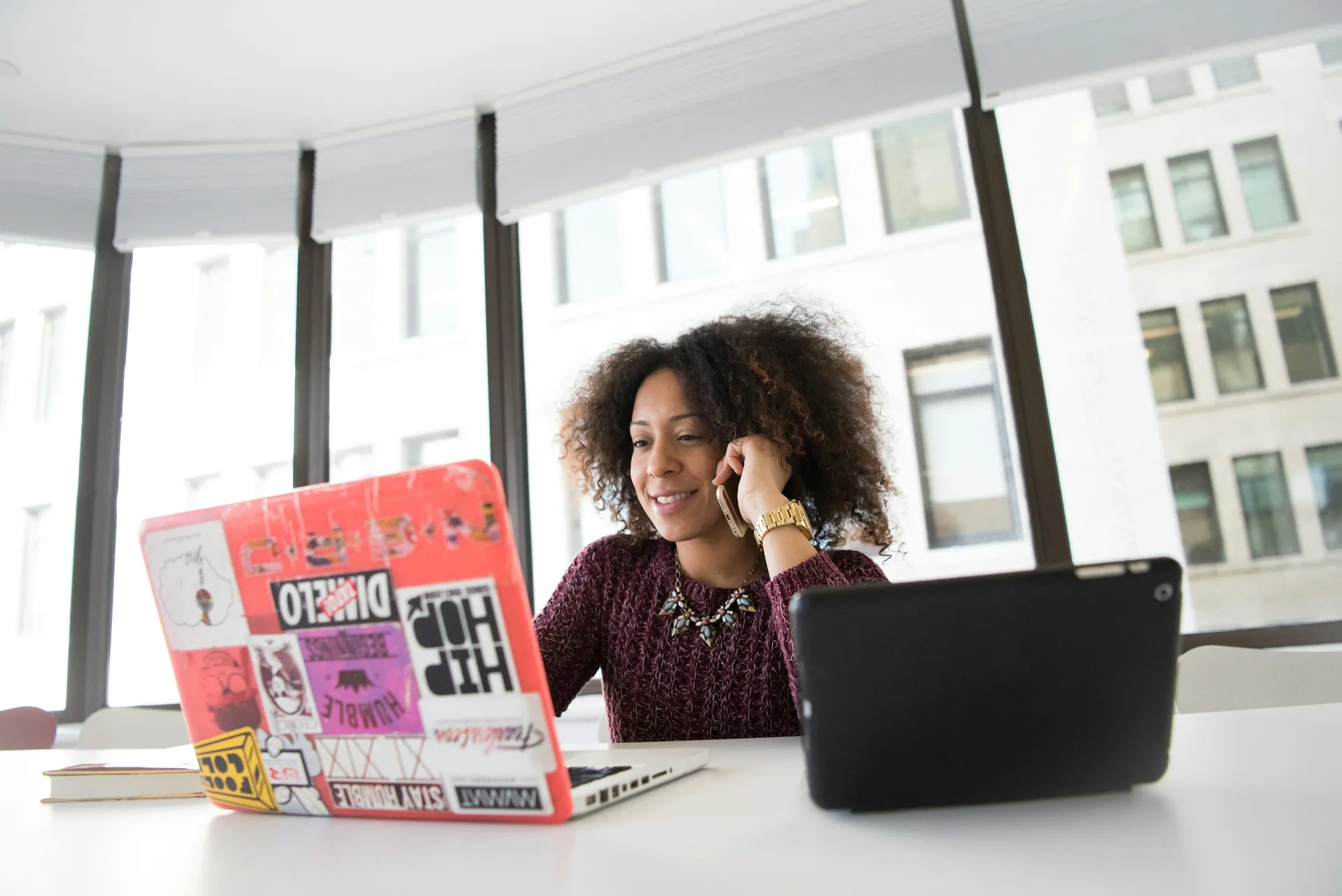 Black woman working independently on a laptop in a warm, focused setting.