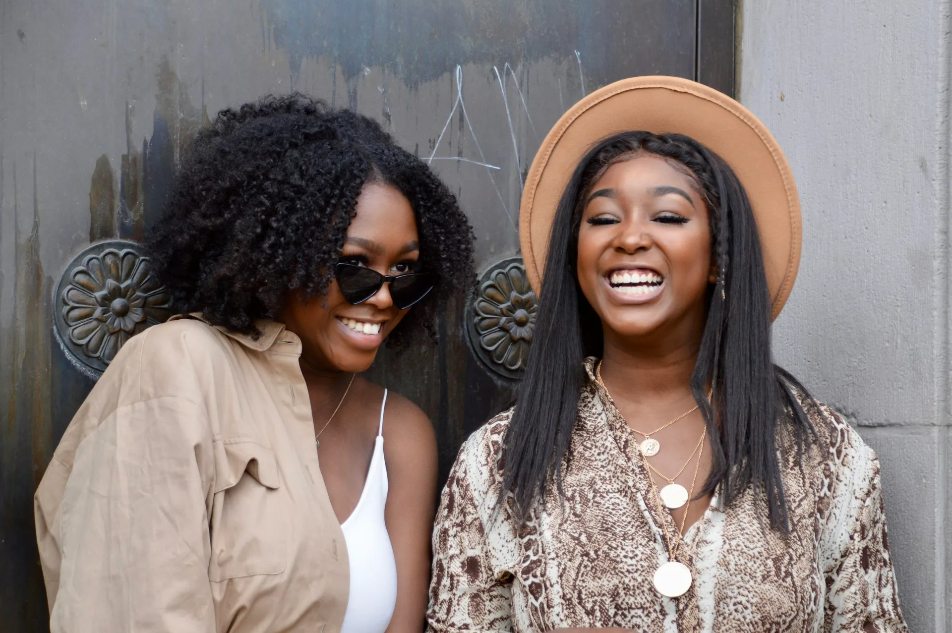 Two Black women standing together with warmth and confidence.